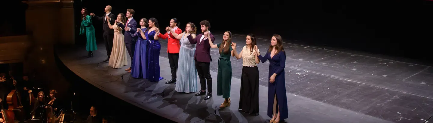 Grupo de cantantes saludando sobre el escenario