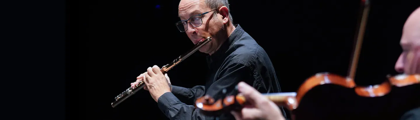 Intérprete de flauta y músicos de cuerda en concierto