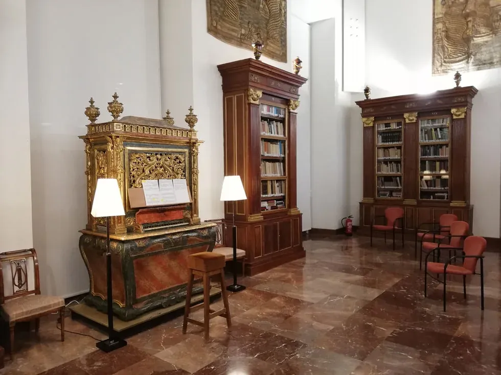 Pequeño órgano realejo dorado entre librerías y vitrinas de las Salas Nobles del Museo Arqueológico Nacional