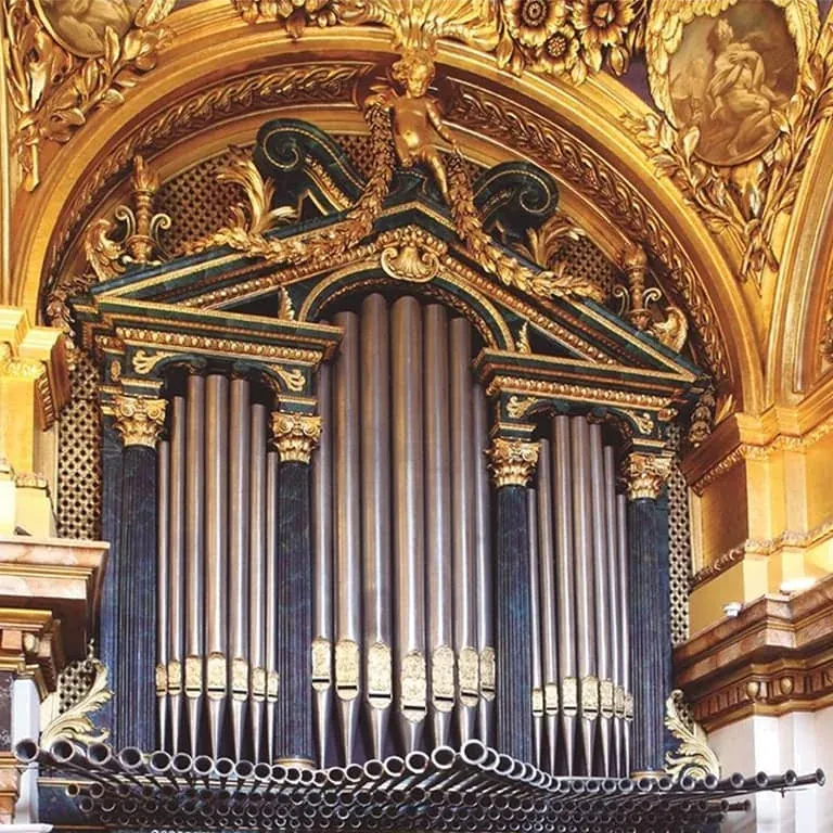 Tubos del órgano Bosch entre columnas oscuras y decoración dorada en la Capilla Real